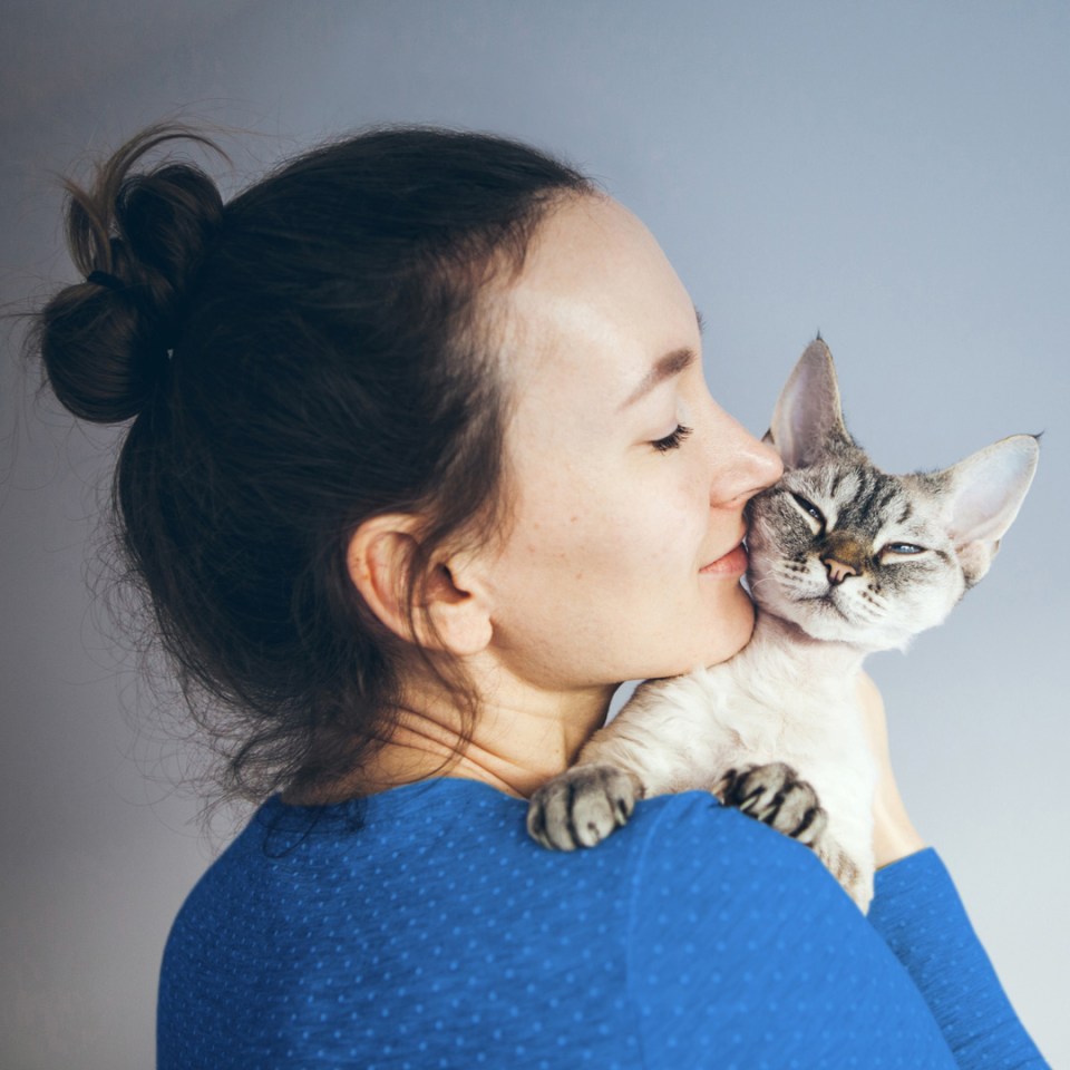 Une femme enlacant tendrement son chat.