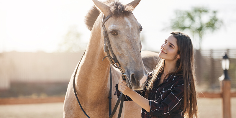 Une femme regardant affectueusement son cheval.